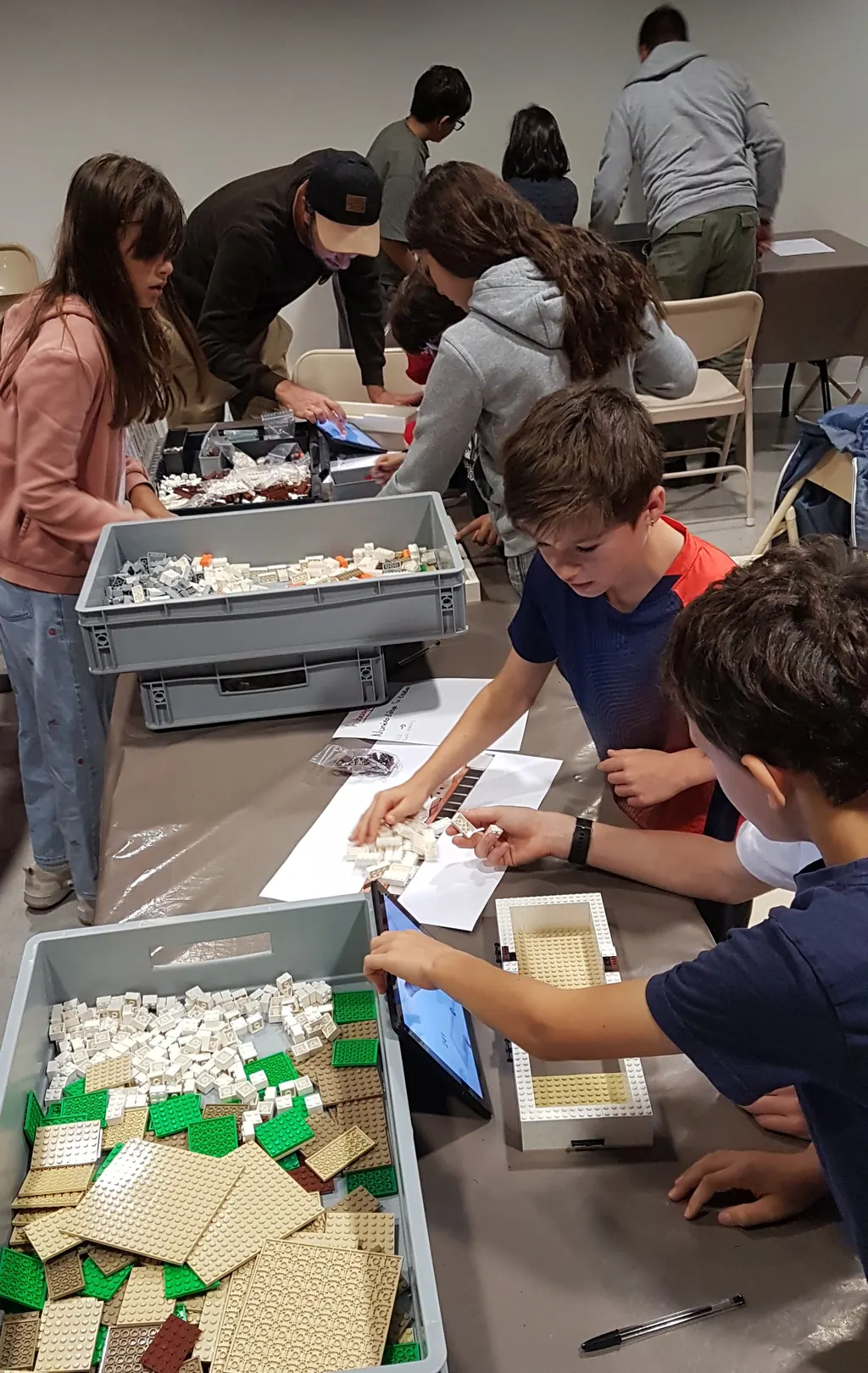 Groupe de participants autour de la table de construction lors d'un atelier