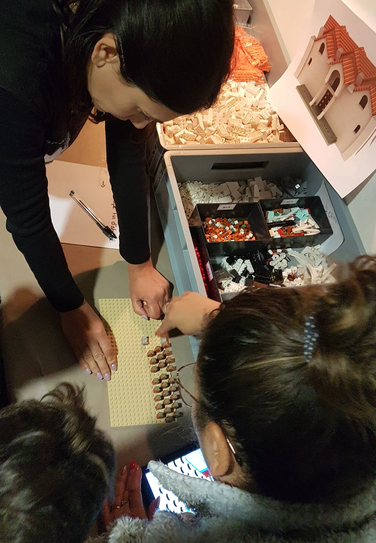 Bacs de pièces triées et mains au travail pendant un atelier