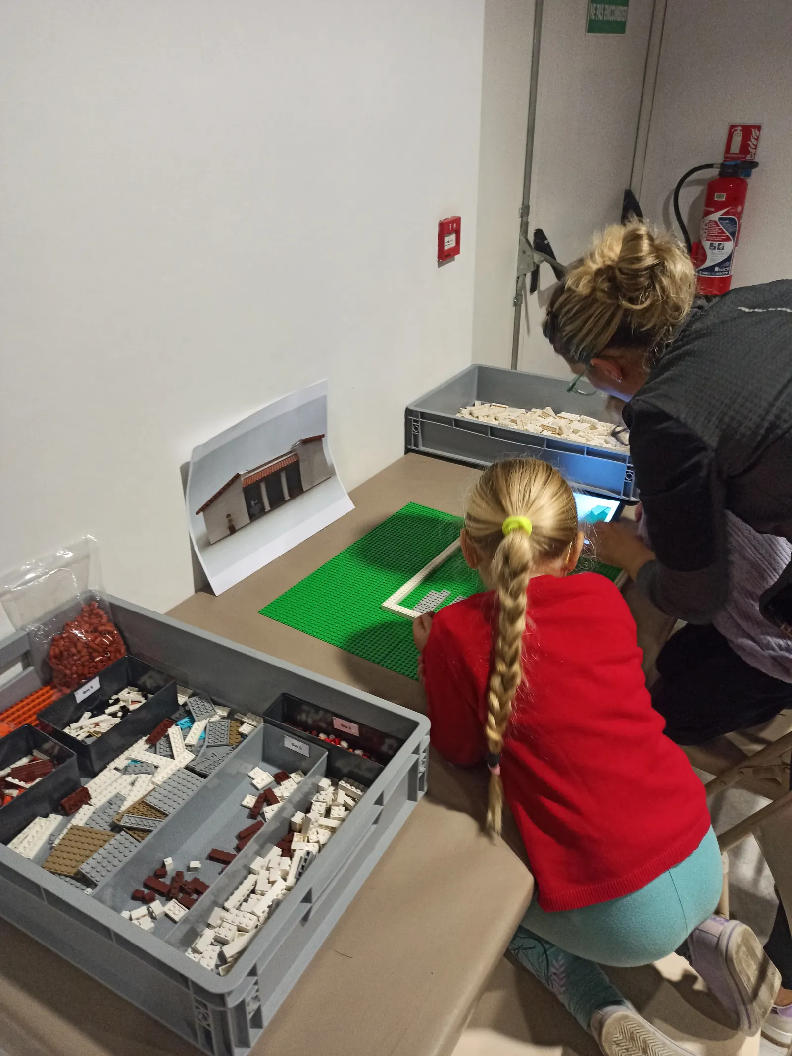 Enfants assemblant ensemble une maquette en briques pendant un atelier