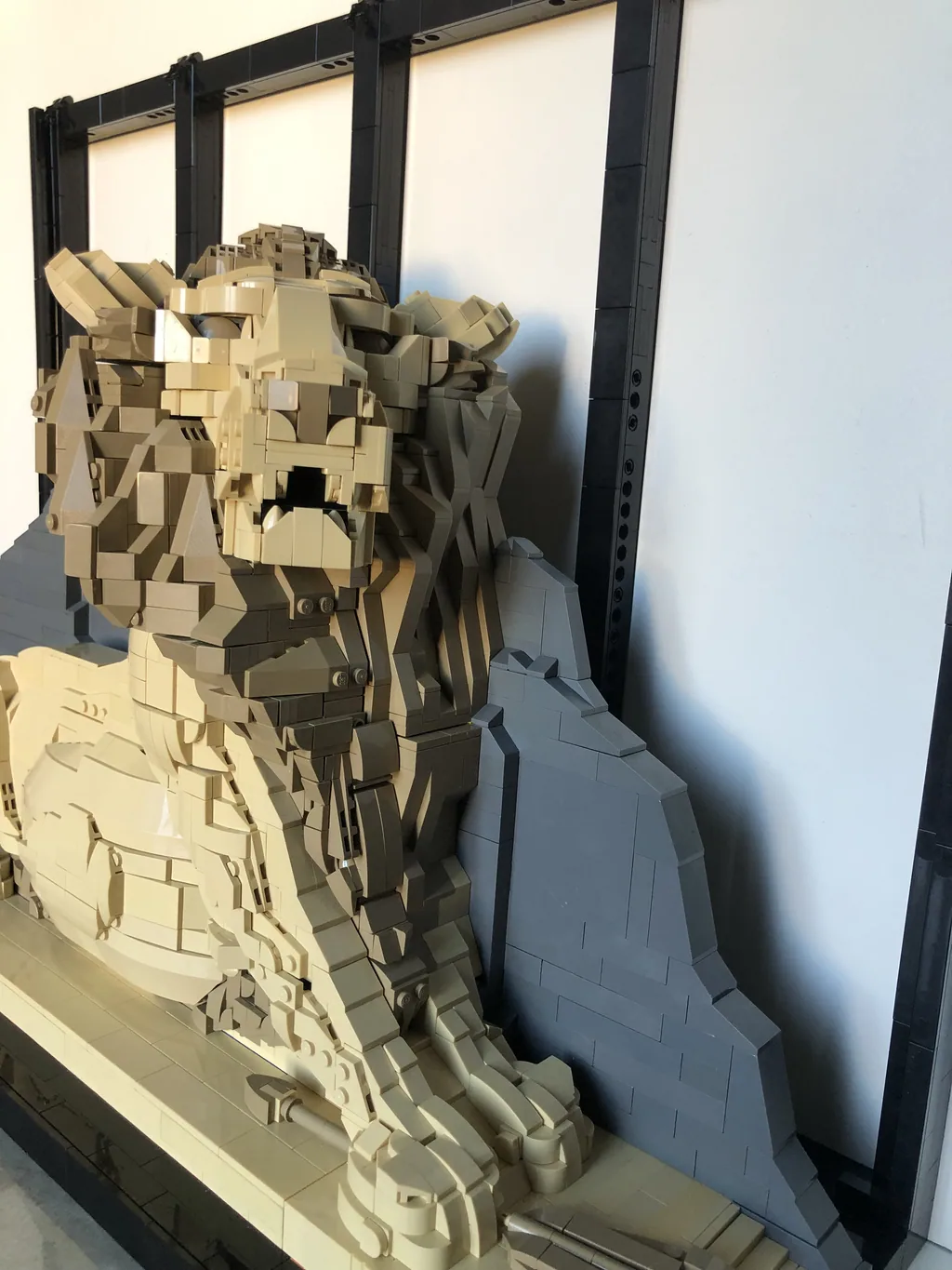 Le Lion de Belfort en briques devant sa paroi rocheuse grise
